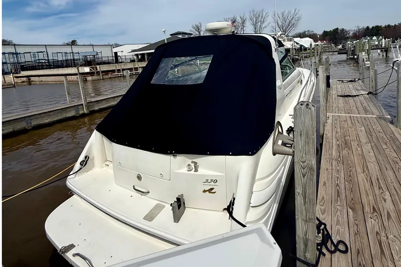 Slide: The Image of 1996 Sea Ray boat docked at marina with black cover and wooden pier. - 3