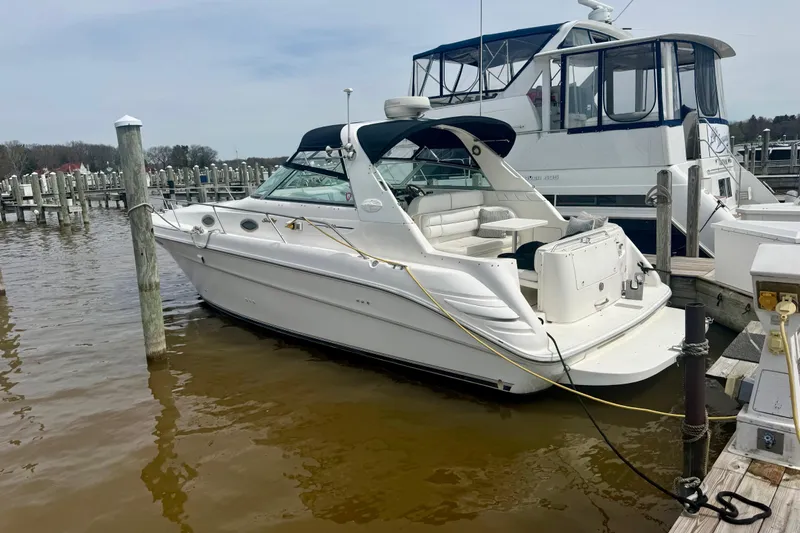 Slide: The Image of 1996 Sea Ray boat docked at marina, featuring white exterior and spacious seating area. - 4