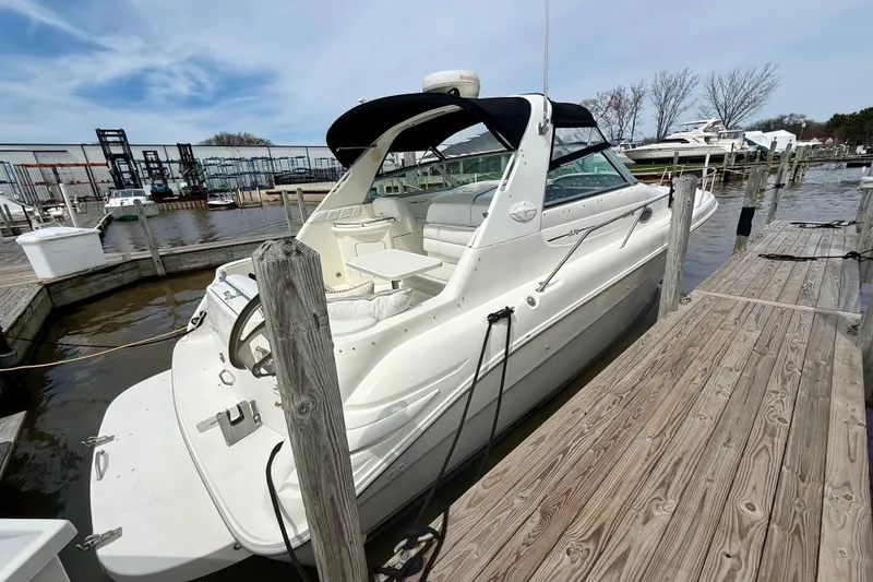 Slide: The Image of 1996 Sea Ray boat docked at marina, featuring white exterior and spacious seating area. - 5