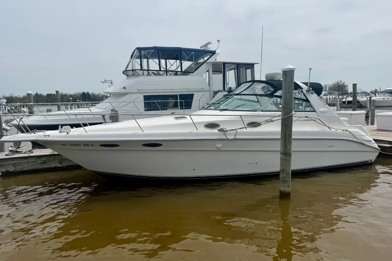 Slide: The Image of 1996 Sea Ray boat docked at marina, side view with calm water. - 7