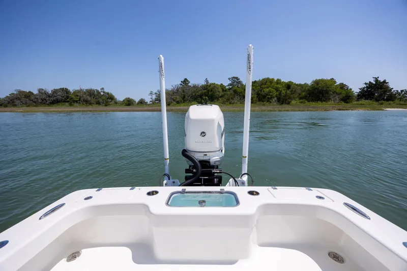 Slide: The Image of ZCB Freemason 26 boat, 2022 model, on calm water with lush green shoreline. - 12