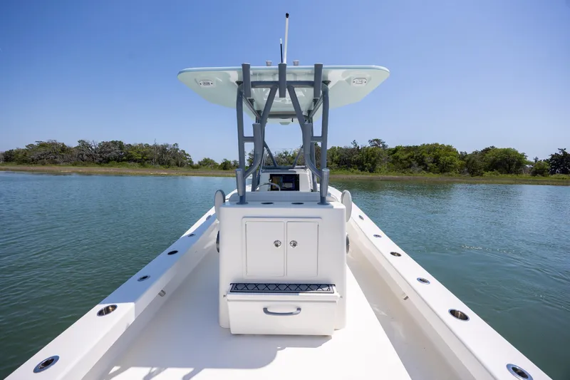 Slide: The Image of 2022 ZCB Freemason 26 boat on calm water, clear sky, and lush shoreline. - 20