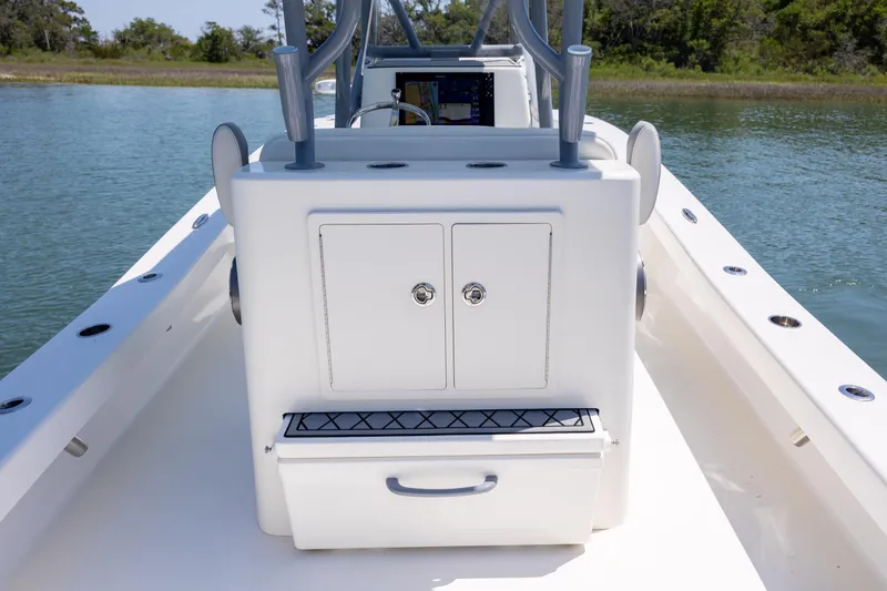 Slide: The Image of 2022 ZCB Freemason 26 boat interior with storage compartments on calm water. - 21