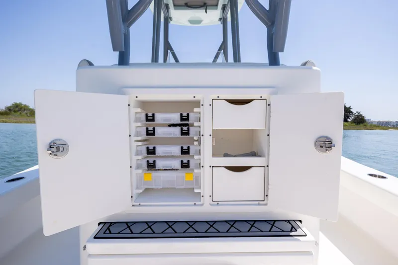 Slide: The Image of Open storage compartment on ZCB Freemason 26 boat, showcasing organized tackle boxes and drawers. - 22