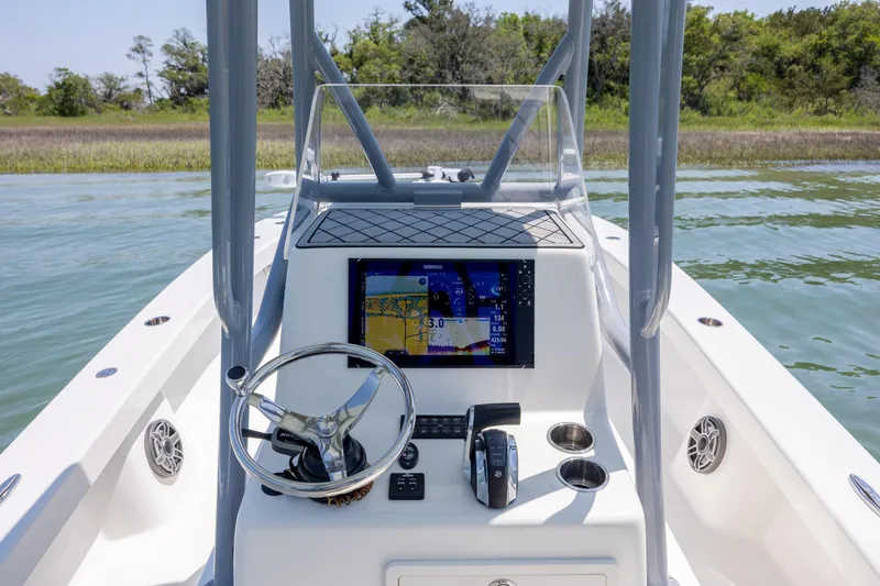 Slide: The Image of 2022 ZCB Freemason 26 boat console with navigation display on calm water. - 26