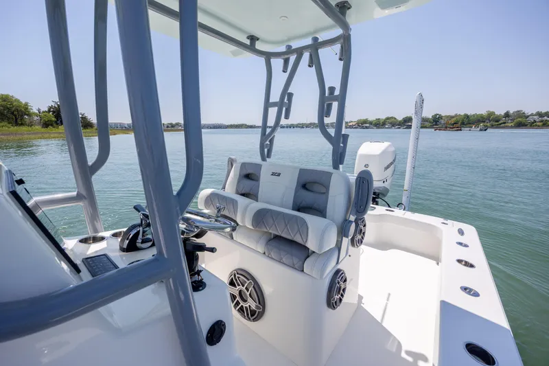Slide: The Image of 2022 ZCB Freemason 26 boat interior with steering console and seating on calm water. - 28