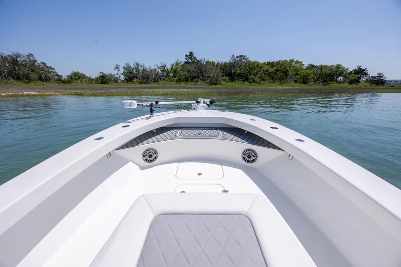 Slide: The Image of Bow view of 2022 ZCB Freemason 26 boat on calm water, near lush shoreline. - 32