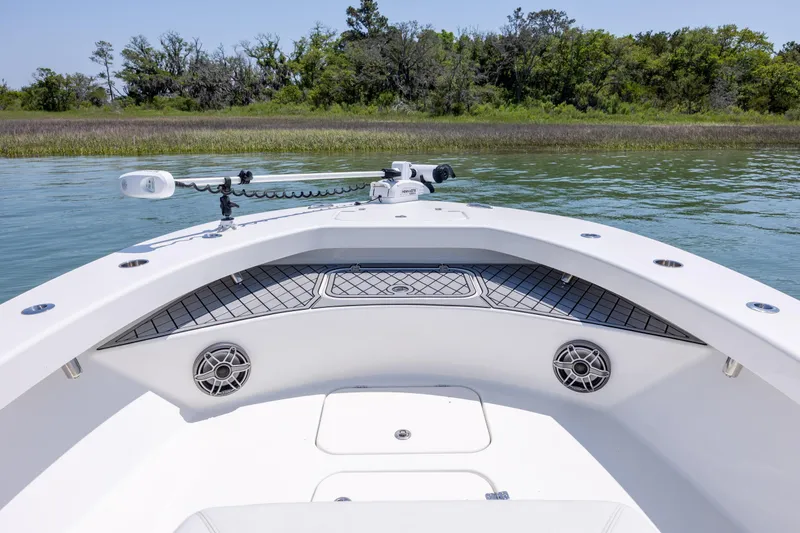 Slide: The Image of Bow view of 2022 ZCB Freemason 26 boat with speakers and trolling motor on calm water. - 33