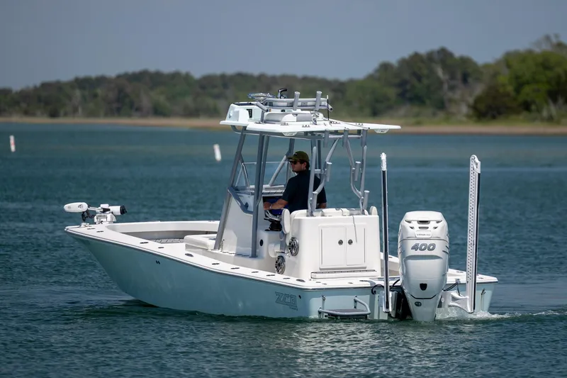 Slide: The Image of A 2022 ZCB Freemason 26 boat cruising on a calm lake with a person onboard. - 4