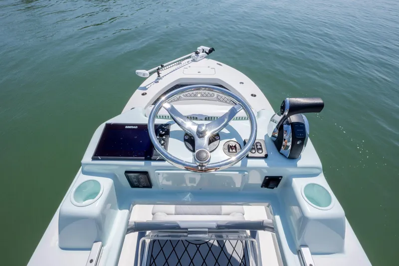 Slide: The Image of 2022 ZCB Freemason 26 boat helm with steering wheel and controls on calm water. - 41