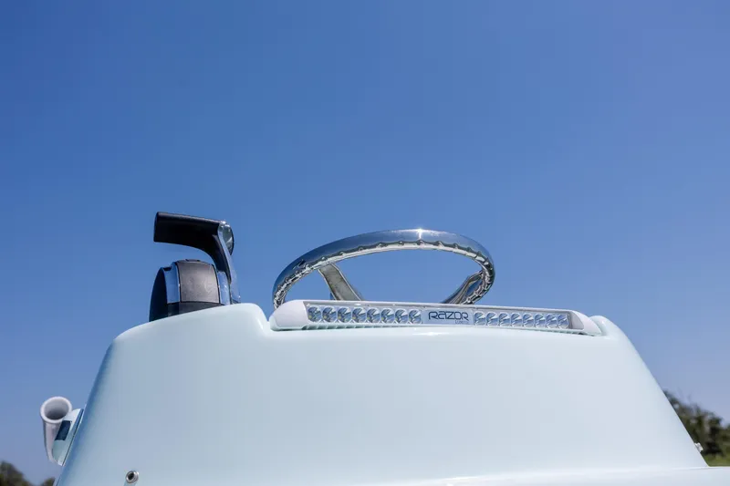 Slide: The Image of Steering wheel of 2022 ZCB Freemason 26 boat under clear blue sky. - 45