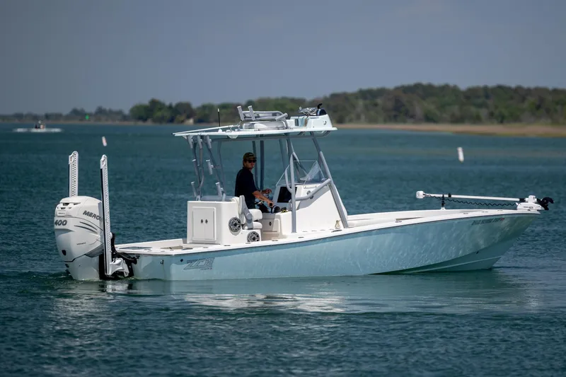 Slide: The Image of 2022 ZCB Freemason 26 boat cruising on a calm lake with a Mercury engine. - 7