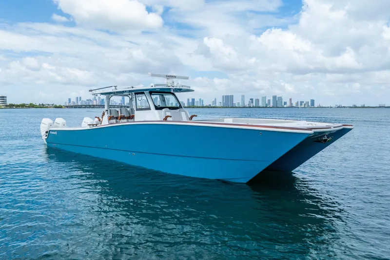 Slide: The Image of Blue 2024 Freeman 47 boat on water with city skyline in background. - 13