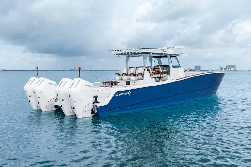 Slide: The Image of 2024 Freeman 47 boat with triple Mercury engines on calm water. - 14