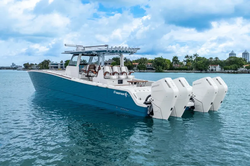 Slide: The Image of 2024 Freeman 47 boat with four engines on calm water, under a cloudy sky. - 16