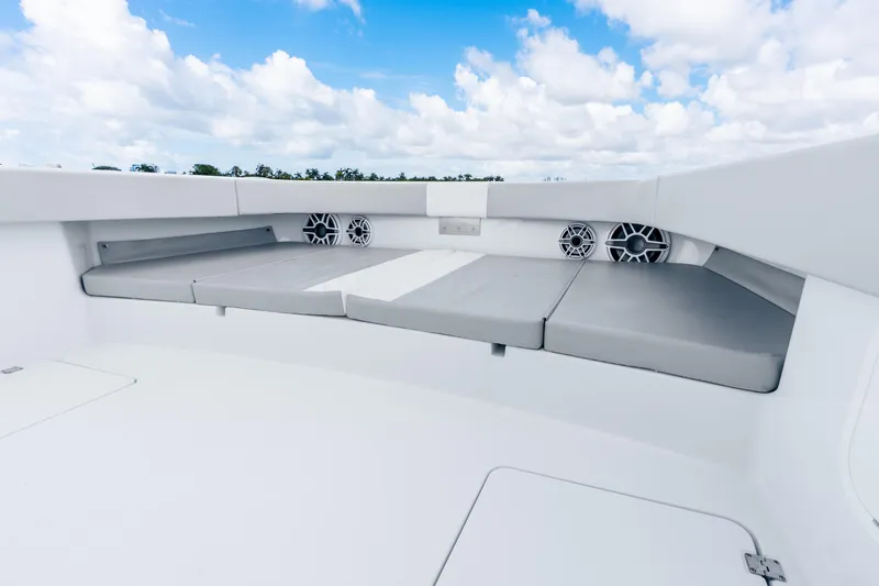 Slide: The Image of 2024 Freeman 47 boat interior with cushioned seating and speakers under a blue sky. - 36