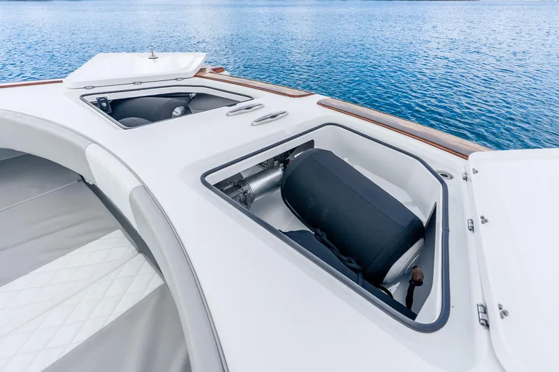Slide: The Image of 2024 Freeman 47 boat deck with open storage compartments on calm water. - 41