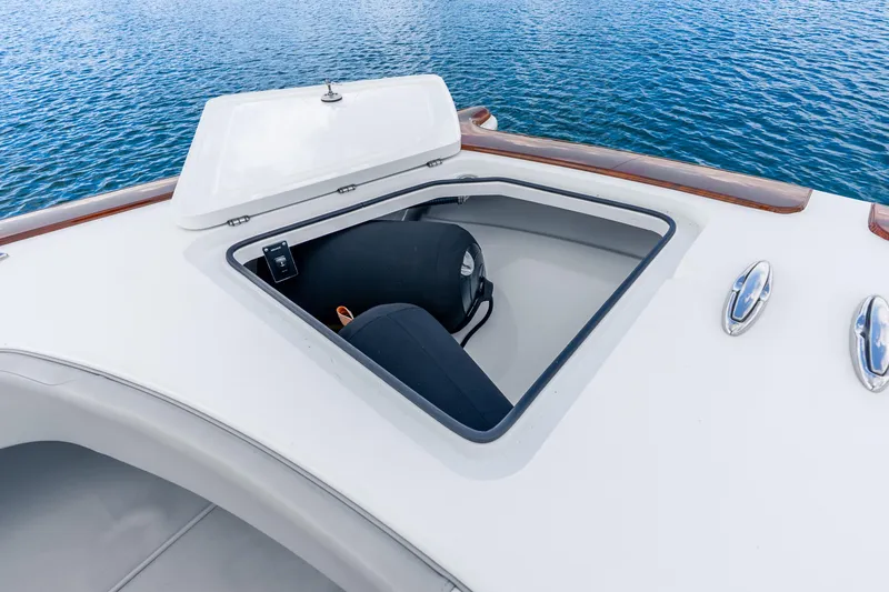 Slide: The Image of Open hatch on 2024 Freeman 47 boat, revealing storage compartment by the water. - 43