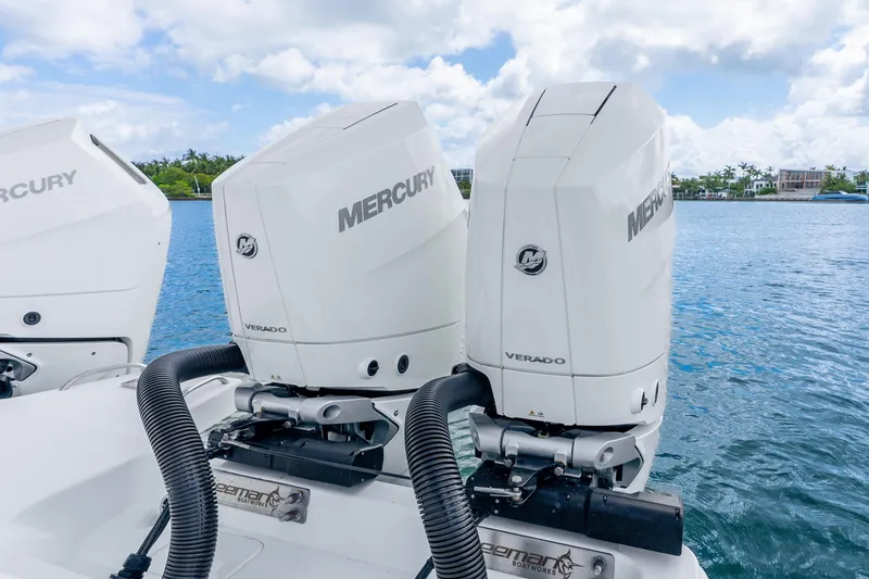 Slide: The Image of Twin Mercury Verado engines on a 2024 Freeman 47 boat, docked by the water. - 58