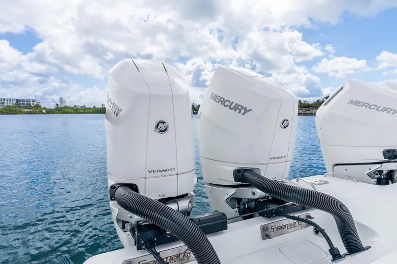 Slide: The Image of Three Mercury Verado outboard engines on a 2024 Freeman 47 boat, docked on a sunny day. - 59