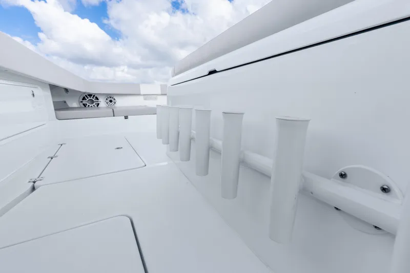 Slide: The Image of 2024 Freeman 47 boat deck with rod holders and speakers under a cloudy sky. - 65
