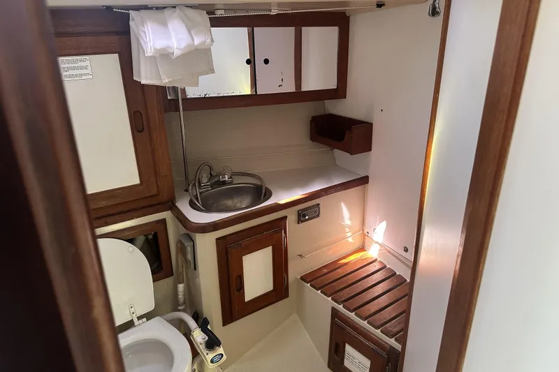 Slide: The Image of Interior of 1989 Catalina 36 MkII yacht bathroom with sink, toilet, and wooden cabinetry. - 15