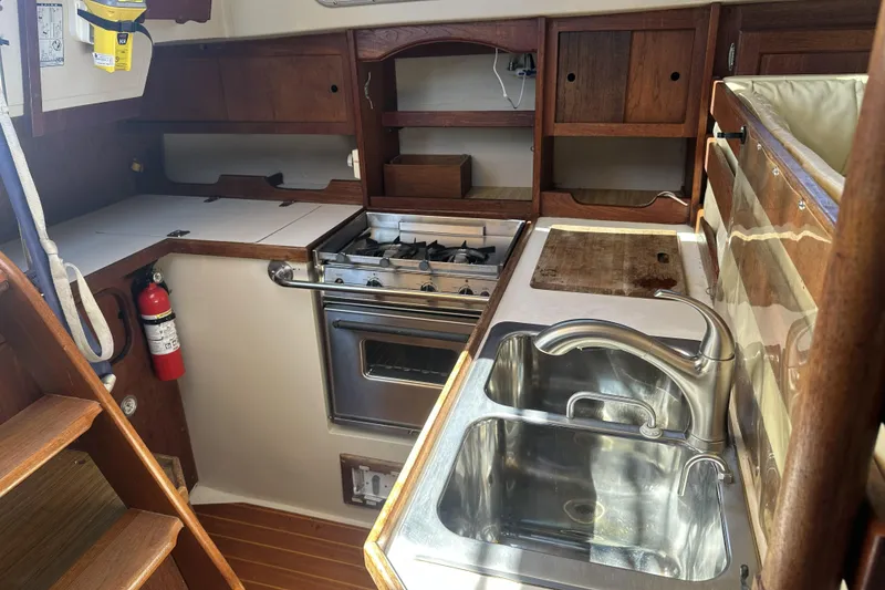 Slide: The Image of Galley kitchen in 1989 Catalina 36 MkII sailboat with stove, sink, and wooden cabinetry. - 19