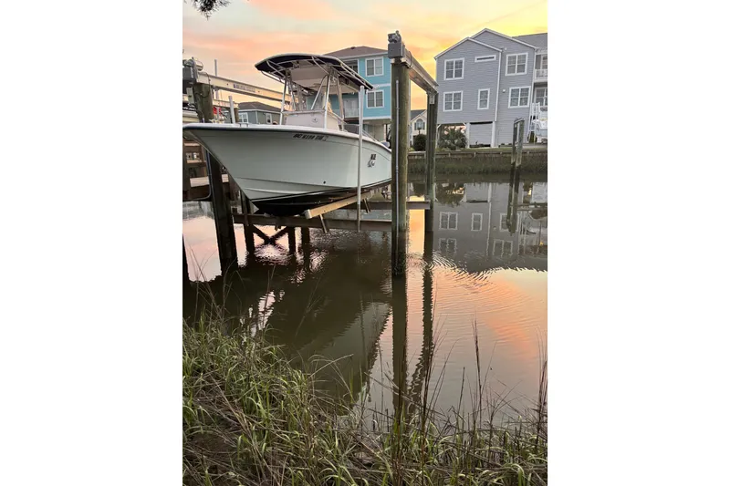 The Image of 2006 Grady-White Advance 257 boat docked at sunset near waterfront homes. - 1