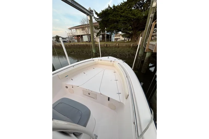 Slide: The Image of 2006 Grady-White Advance 257 boat docked near a wooden pier, surrounded by trees. - 4