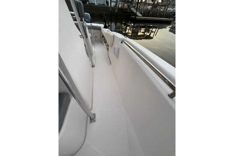 Slide: The Image of 2006 Grady-White Advance 257 boat deck with railing, docked by calm water. - 6