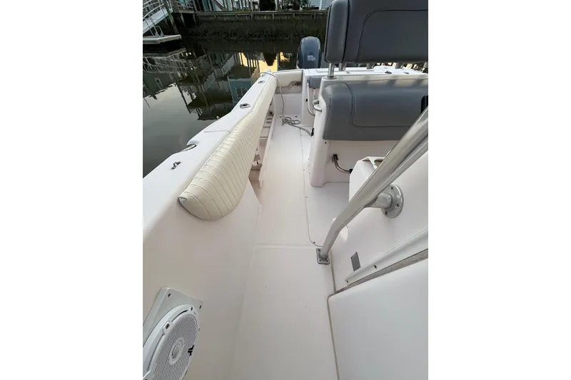 Slide: The Image of 2006 Grady-White Advance 257 boat interior with seating and railing, docked by calm water. - 7