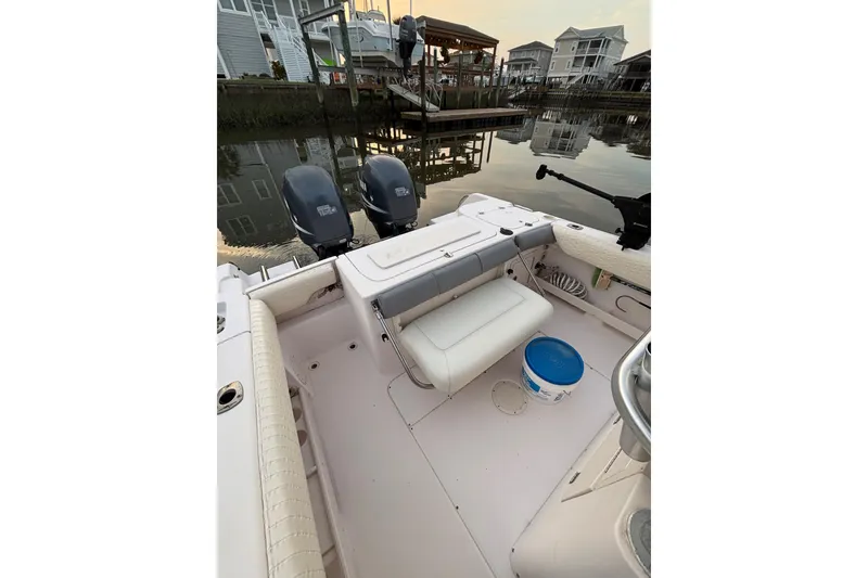 Slide: The Image of 2006 Grady-White Advance 257 boat interior with dual engines, docked near waterfront homes. - 9