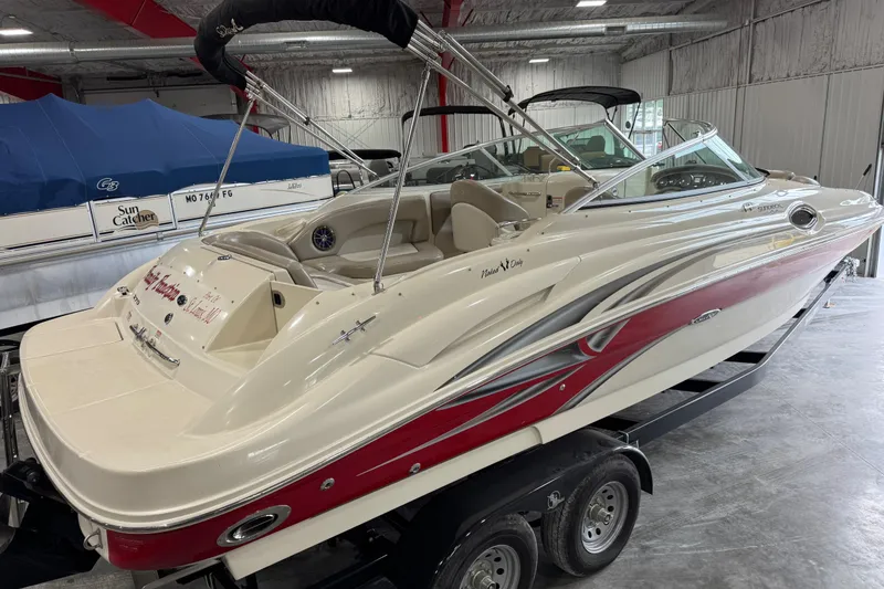 Slide: The Image of 2003 Sea Ray 270 Sundeck boat in indoor storage, featuring sleek design and red accents. - 5