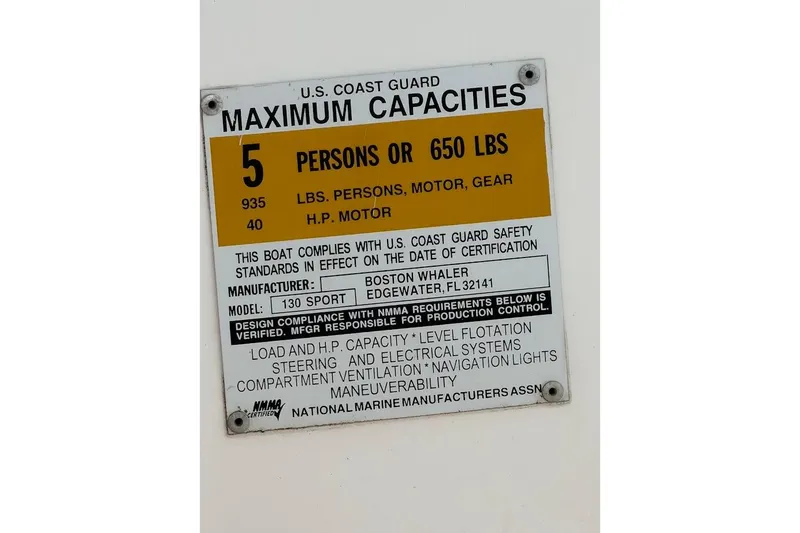 Slide: The Image of 2002 Boston Whaler 130 Sport capacity plate, 5 persons or 650 lbs, safety compliance. - 12