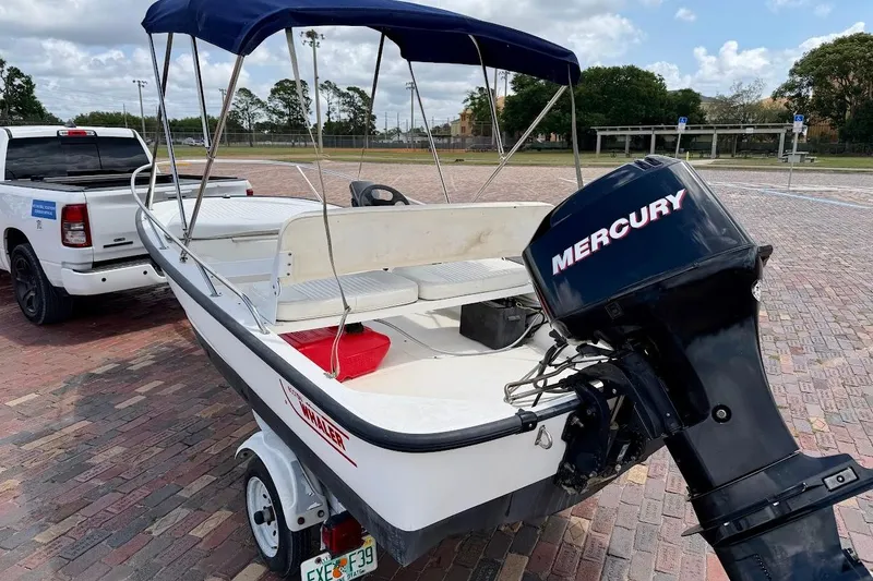 Slide: The Image of 2002 Boston Whaler 130 Sport boat with Mercury engine, parked on a trailer. - 4