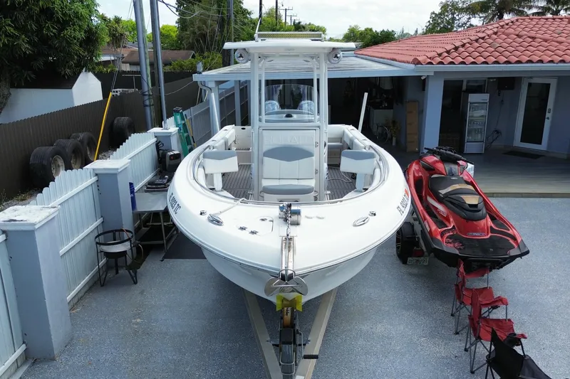 Slide: The Image of 2022 Robalo R242 Center Console boat parked beside a red jet ski. - 12