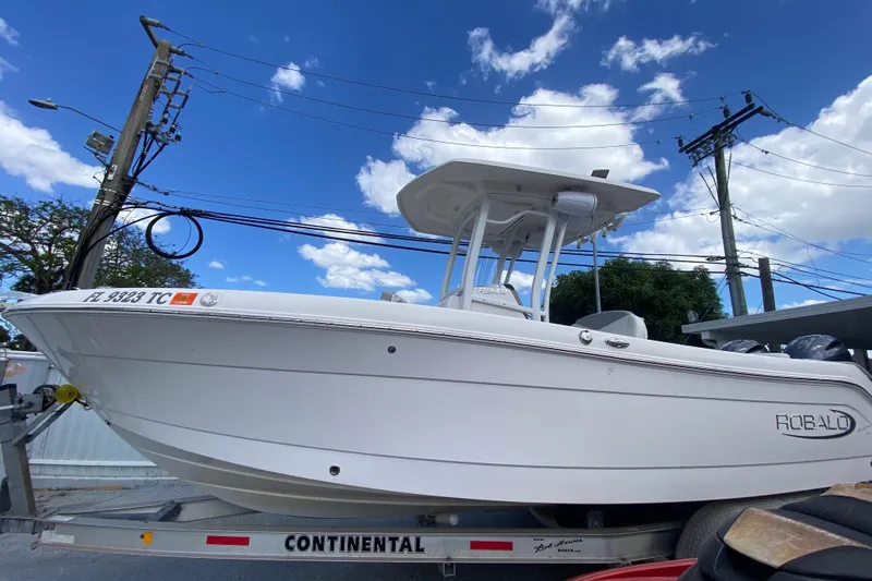 Slide: The Image of 2022 Robalo R242 Center Console boat on trailer under blue sky. - 2