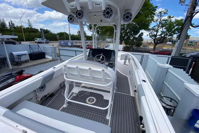 Slide: The Image of 2022 Robalo R242 Center Console boat with modern helm and seating, docked outdoors. - 23