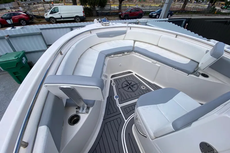 Slide: The Image of 2022 Robalo R242 Center Console boat interior with cushioned seating and compass design flooring. - 34