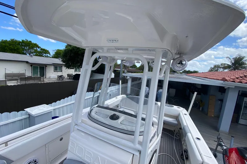 Slide: The Image of 2022 Robalo R242 Center Console boat with T-top in residential driveway. - 40