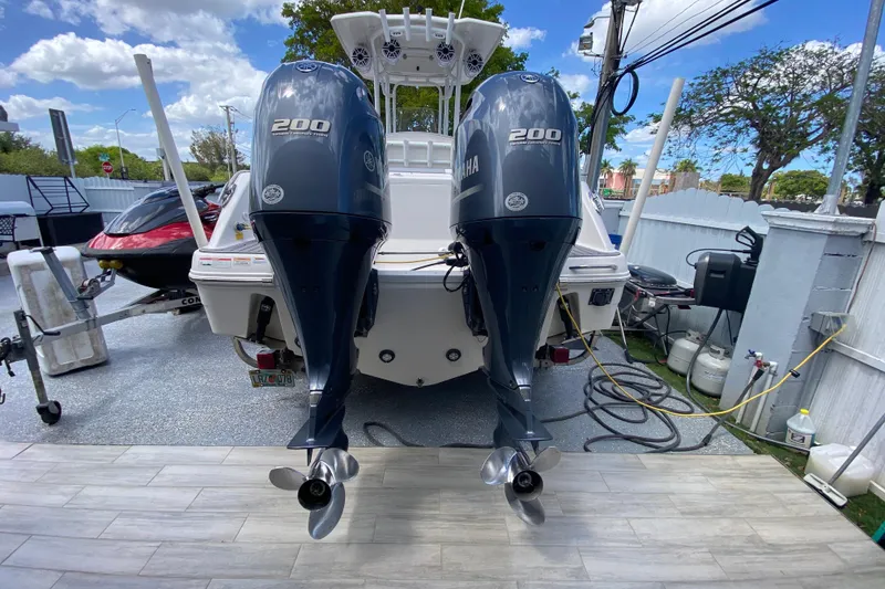 Slide: The Image of 2022 Robalo R242 Center Console with twin Yamaha 200 engines, parked outdoors. - 43