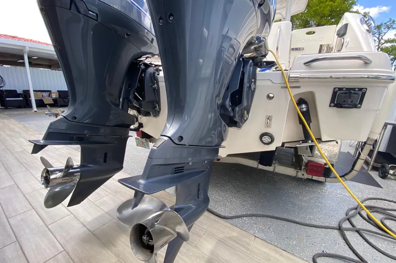 Slide: The Image of 2022 Robalo R242 Center Console boat with dual outboard motors in a garage setting. - 46