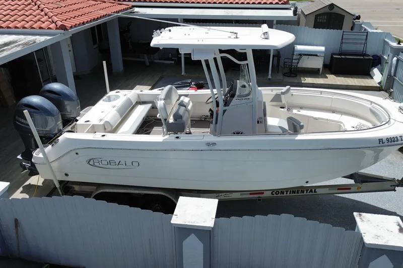 Slide: The Image of 2022 Robalo R242 Center Console boat with twin Yamaha engines on a trailer. - 5