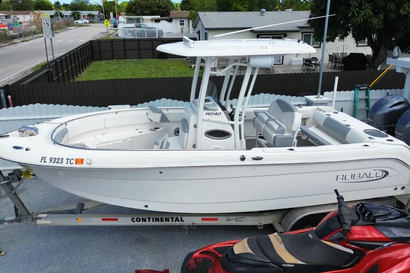 Slide: The Image of 2022 Robalo R242 Center Console boat on trailer, parked in residential area. - 6