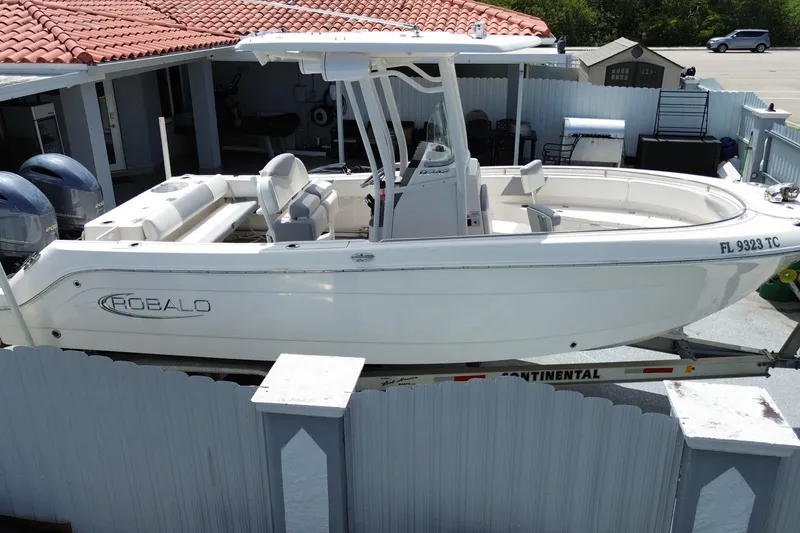 Slide: The Image of 2022 Robalo R242 Center Console boat on trailer, parked near a house. - 7