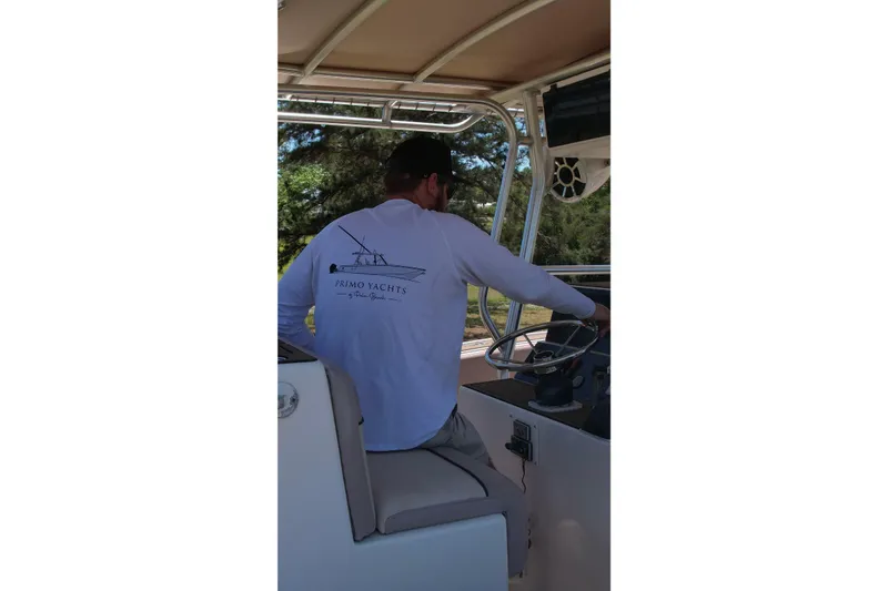 Slide: The Image of Man steering a 2007 Dusky 33 Open Fisherman boat, wearing a "Primo Yachts" shirt. - 8