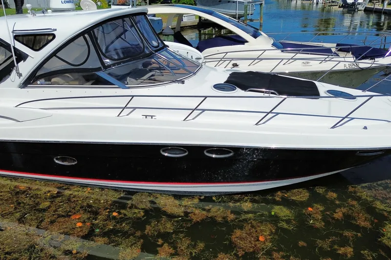 Slide: The Image of 2006 Regal Commodore 3560 IB yacht docked at marina, sleek design, calm water. - 12