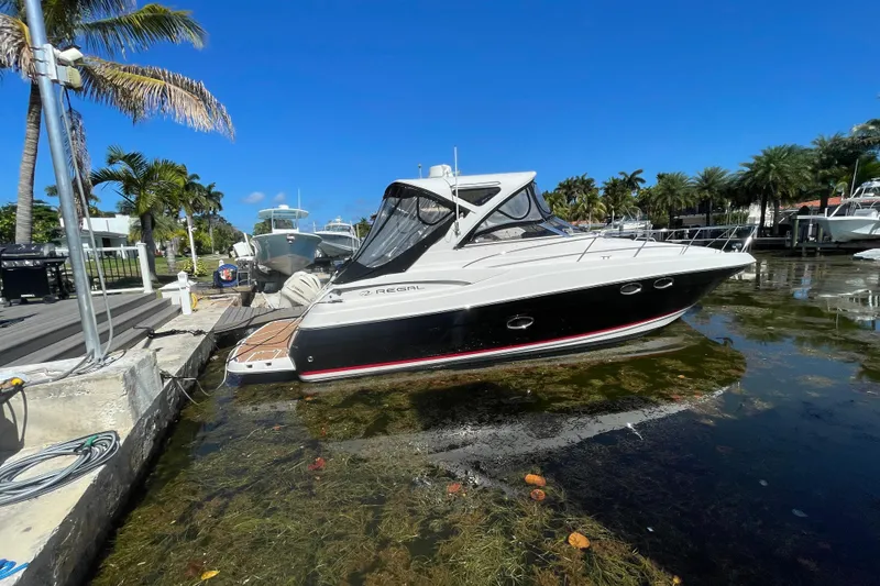 Slide: The Image of 2006 Regal Commodore 3560 IB yacht docked in a sunny marina, surrounded by palm trees. - 15