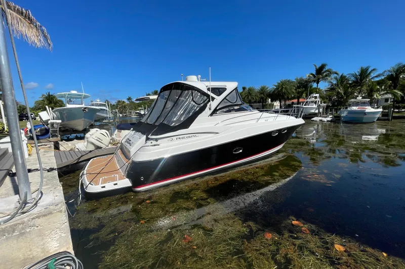 Slide: The Image of 2006 Regal Commodore 3560 IB yacht docked in a scenic marina with palm trees. - 16