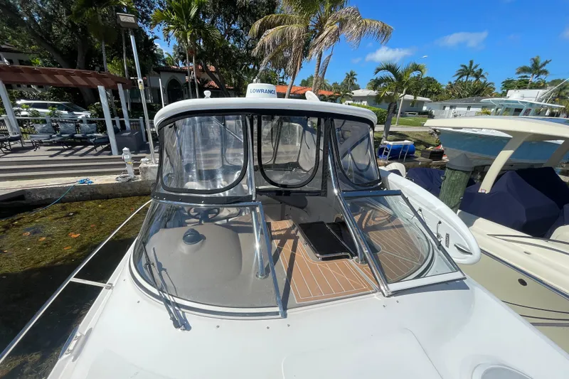 Slide: The Image of 2006 Regal Commodore 3560 IB boat docked, featuring a sleek design and clear canopy. - 18